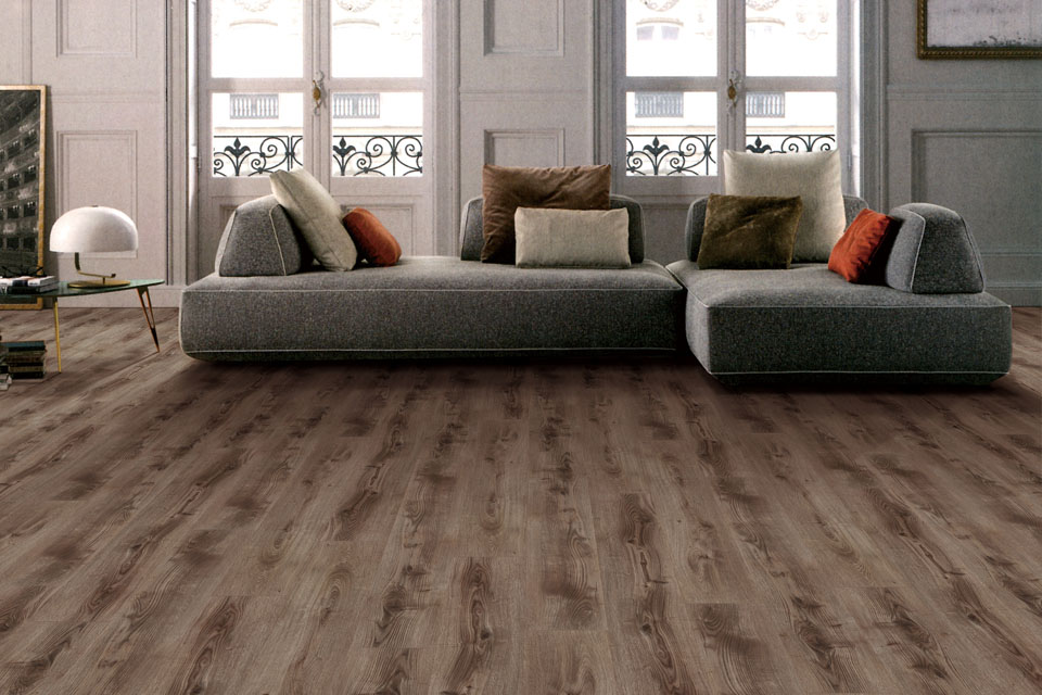 mid century modern grey couch with pillows in traditional home with realistic wood-look luxury vinyl plank flooring 